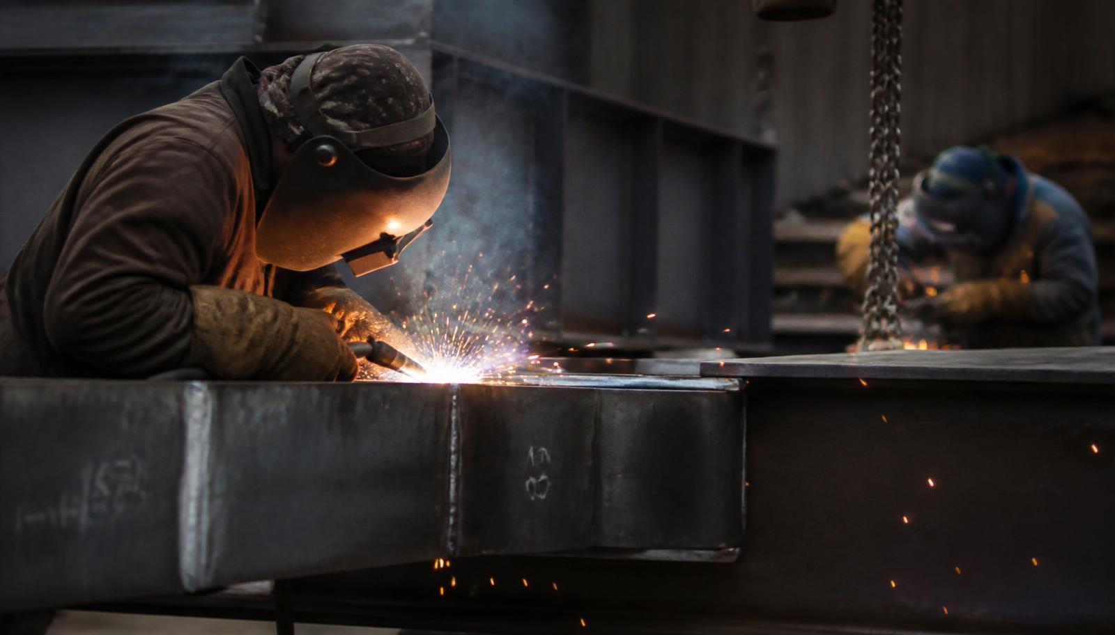 Filipino welders welding steel structures with bright arc sparks